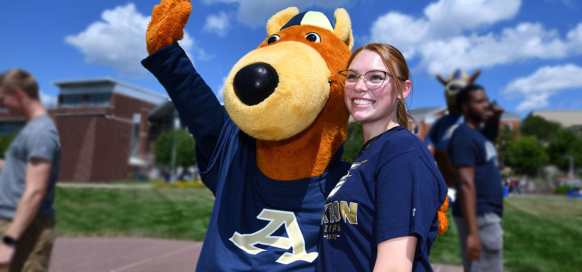 A transfer student with Zippy at The University of ϲʹ hanging out on campus.